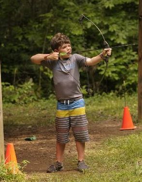 Camper practicing archery at the outdoor range at Athens YMCA Camps
