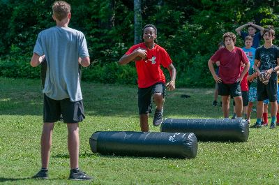Campers practicing football drills on a grassy field at Athens YMCA Camps